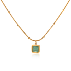 Macro detail of square green cat-eye stone pendant on golden beaded snake chain