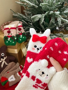 Close-up of thick coral fleece Christmas socks featuring cute cartoon animal motifs