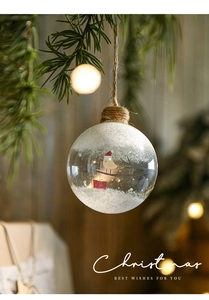 Detail of 8cm glass Christmas ball with white snowflake pattern hanging on a festive tree