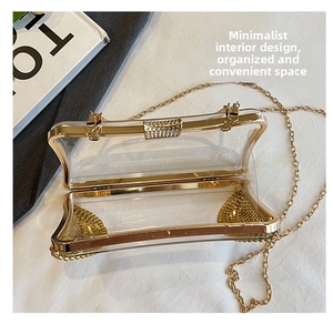 Top view of open clear acrylic evening bag with gold chain and rhinestone clasp