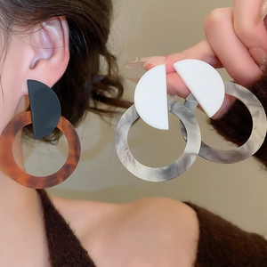 Detail shot of vintage resin hoop earrings featuring amber and marble pattern texture
