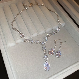 Detailed view of silver teardrop jewelry set with sparkling rhinestones in a gray velvet box