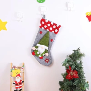 Detailed view of gray felt Christmas stocking with gnome plush and snowflake embroidery