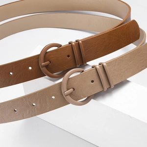 Minimalist faux leather skinny belts in brown and beige with round buckles on white blocks