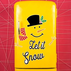 Detail of Let it Snow lettering and snowman magnetic decal on a yellow refrigerator