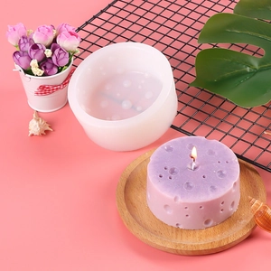 White silicone cheese mold for DIY crafts next to a purple cheese shaped candle