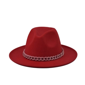 Détail d'un chapeau fedora rouge en feutre avec une chaîne décorative en plastique rose