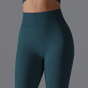Detail view of seamless dark green yoga pants featuring a wide ribbed high waistband for support