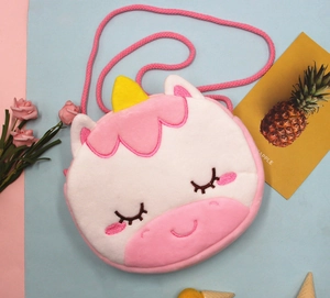 Détail d'un sac licorne en peluche rose avec broderies et bandoulière tressée