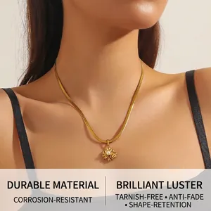 Close-up of gold-plated lotus flower pendant with pearl on a sleek snake chain necklace