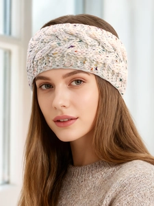 Close-up of cream chunky knit headband with colorful flecks and warm cable pattern