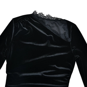 Détail d'une robe en velours noir avec dentelle asymétrique et décolleté en tulle transparent