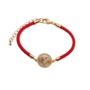 Detailed view of red braided cord bracelet with gold heart zircon charm and lobster clasp