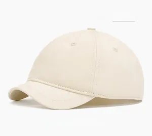 Détail d'une casquette beige à bord court avec trous d'aération et texture en coton sergé