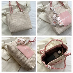 Vue macro des détails du sac cabas tissé beige avec poignées roses et foulard en soie