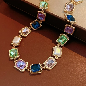 Close-up of vintage square pendant necklace with multi-color crystals in gold setting