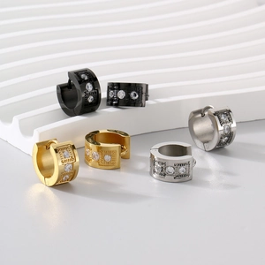 Detail of C-shaped stainless steel huggie earrings with cubic zirconia in three metal colors