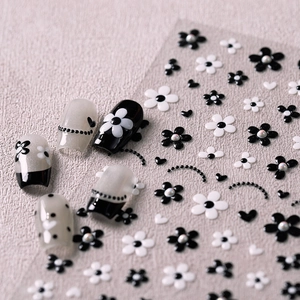 Minimalist black and white flower nail stickers with pearl accents and heart designs