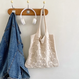 Detail of cream knit tote bag showing soft wool texture and openwork crochet pattern