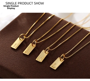 Macro detail of gold-plated rectangle letter pendants I J K L on soft brown velvet