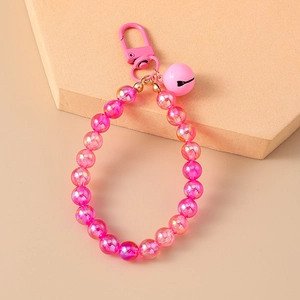 Detailed macro shot of a pink iridescent beaded keychain with a matching bell accessory