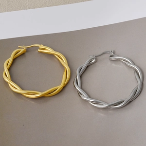 Pair of large minimalist twisted hoop earrings in gold and silver stainless steel finish