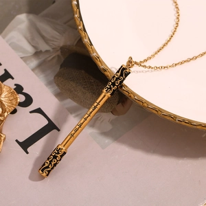 Close-up of golden Ruyi Jingu Bang pendant necklace with engraved Chinese characters