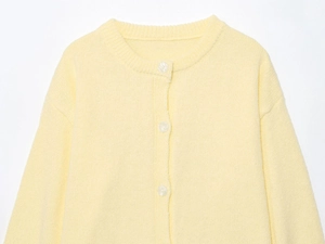 Detailed close-up of soft yellow knit cardigan featuring round neck and matching buttons