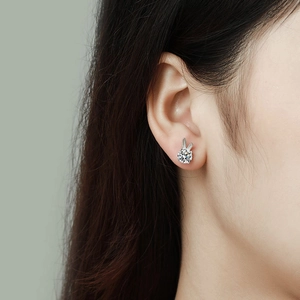 Close-up of silver rabbit-shaped moissanite stud earring worn on model's ear