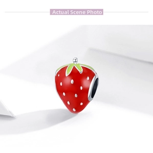 Detailed view of S925 sterling silver strawberry charm with red enamel and green leaves