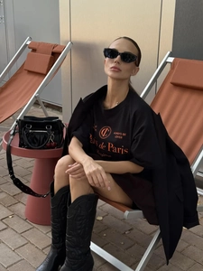 Λεπτομέρεια μαύρου βαμβακερού T-shirt με πορτοκαλί γράμματα Paris και τσάντα με τρουκς