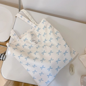 Detailed macro view of light blue bow floral print on a white canvas tote bag material