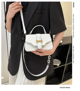 Detail of white mini square bag with gold metal buckle and leather texture