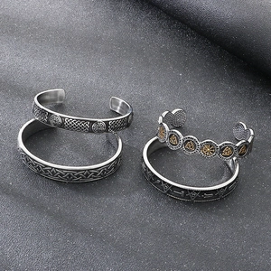 Detail view of four vintage Viking steel bracelets featuring Valknut and Celtic knot patterns