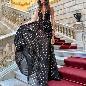 Detail of elegant black and gold polka dot maxi dress with deep V-neck and hollow out ring