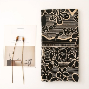 Detail of printed cotton-linen scarf with floral patterns and frayed edges on magazine