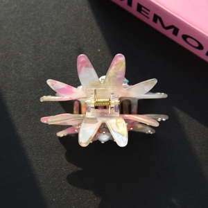 Détail de la pince à cheveux fleurie en acrylique marbré rose avec ressort doré