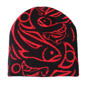 Detaillierte Nahaufnahme des roten Fisch-Jacquardmusters auf einer schwarzen Strickmütze