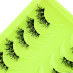 Macro shot of natural voluminous half false eyelashes on a green tray insert