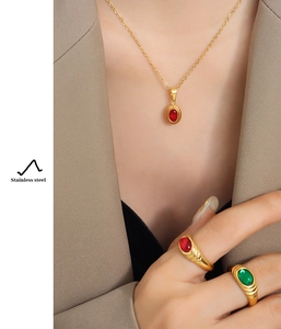 Detail view of a vintage stainless steel jewelry set with red and green gemstones