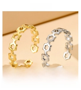 Detail view of hollow star adjustable rings in gold and silver plated metal finishes