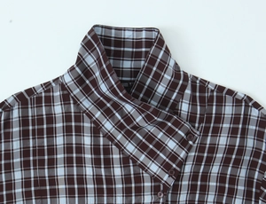 Detail of plaid shirt collar with brown buttons and fine tan-blue woven textile texture