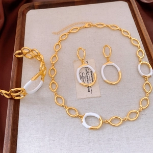 Detail shot of golden geometric hollow necklace, bracelet and earrings jewelry set