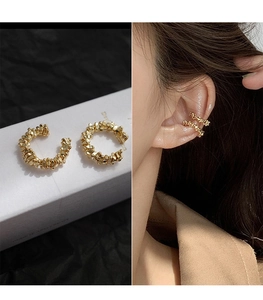Detailed view of gold textured non-piercing ear cuffs on box and model ear