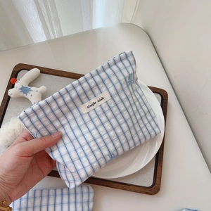 Close-up of blue plaid cotton pouch with a simple wish label in a lifestyle setting