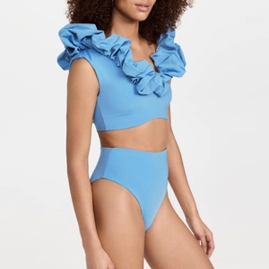 Detail of light blue two-piece swimwear with ruffle puff shoulders and high waist cut