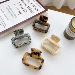 Set of four tortoiseshell and marble acetate hair claws for women in an aesthetic layout