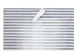 Detailed view of three white plastic measuring spoons with hanging holes on blue textile