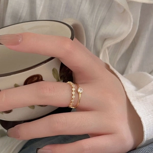 Close-up of 18K gold-plated double-layer ring with sparkling zircons on a hand