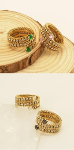 Detail of gold-plated multi-layer ring with twisted borders, crystals, and heart gemstones